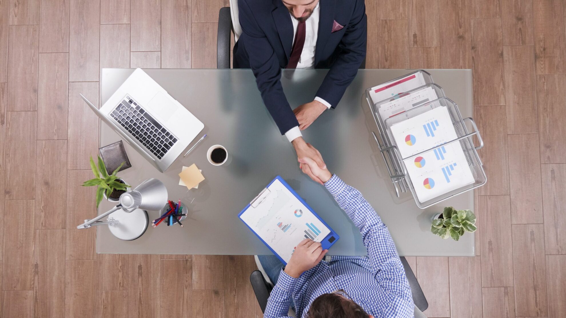 Aerial view of two men shaking hands illustraes blog "4 Questions To Ask Yourself Before Taking Out a Business Loan"