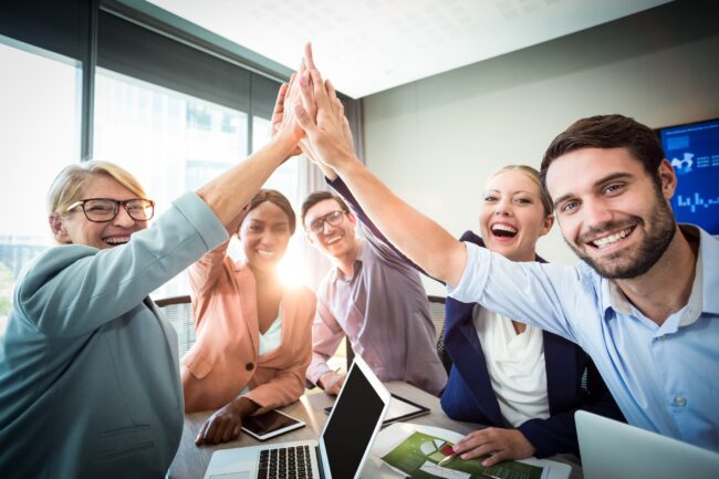 Group of happy employees illustrates blog "Reducing Employee Turnover: How to Keep Your Employees for the Long Haul"