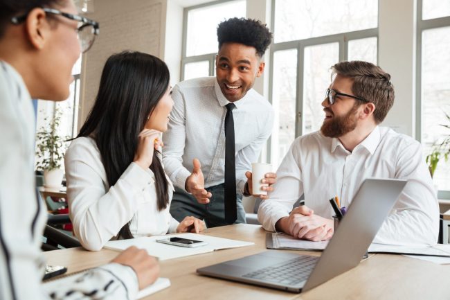 Man introducing himself to other people illustrates blog "Two Simple Ways To Get Your Networking to the Next Level"