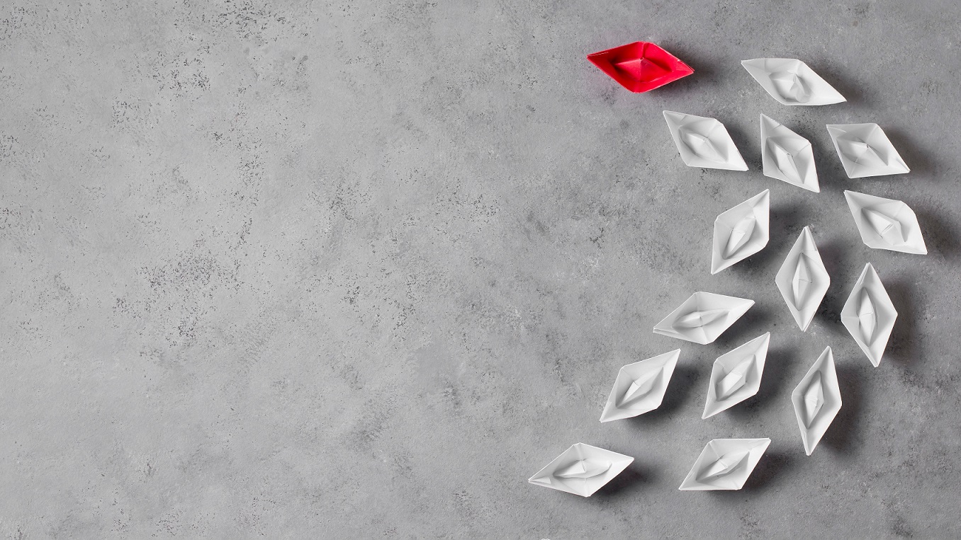 Leadershp-FP Red paper ship guiding white paper ships illustrates blog "5 key Leadership Tips for Entrepreneurs"