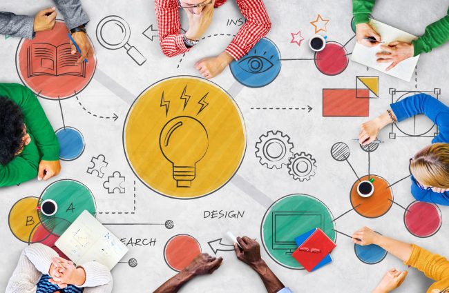 Photo of people sitting at a table with a light bulb drawn on it illustrates blog: "How Small Businesses Can Foster Innovation"