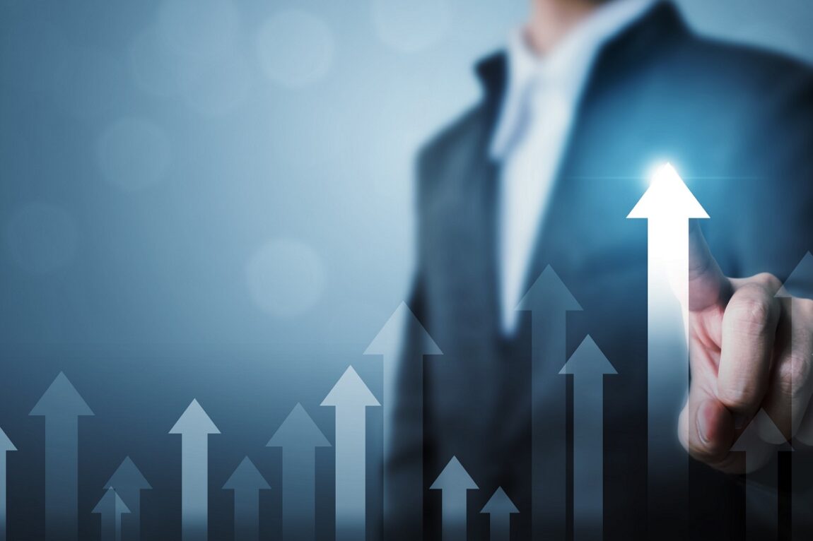 Photo of man touching arrow pointing up illustrates blog "How To Boost Productivity in Your Business"