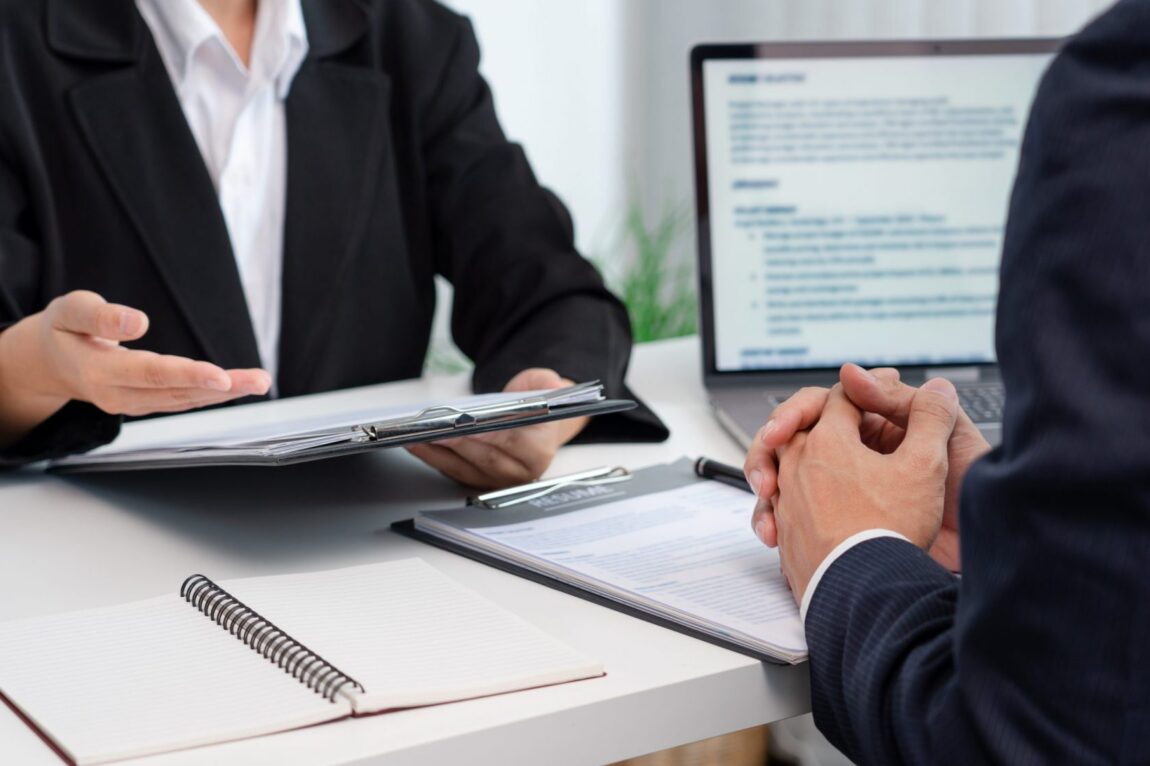 Photo of two businessmen talking at a desk