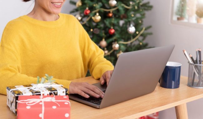 Photo of woman working on laptop illustrates blog: "Considering Seasonal Hiring This Christmas? Keep These Tips in Mind"