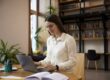 Woman sitting in front of laptop studying.