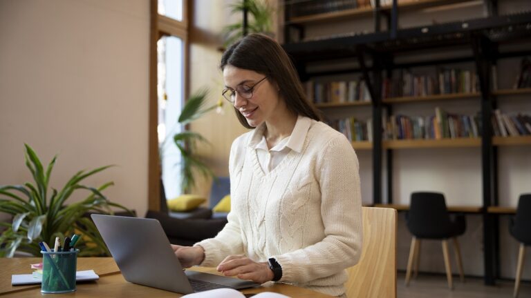 Woman sitting in front of laptop studying.