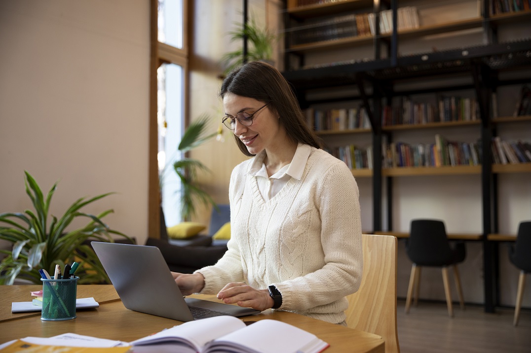 Woman sitting in front of laptop studying.