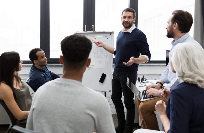 Photo of team during a meeting illustrates blog: "Make Team Meetings More Engaging"