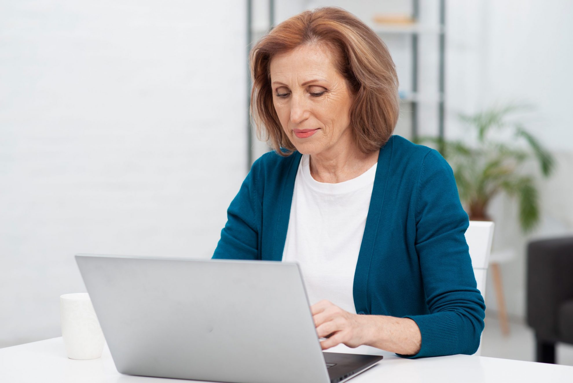 Photo of woman writing on a laptop illustrates blog: 3 Common Grammar Mistakes to Avoid in Your Business Emails
