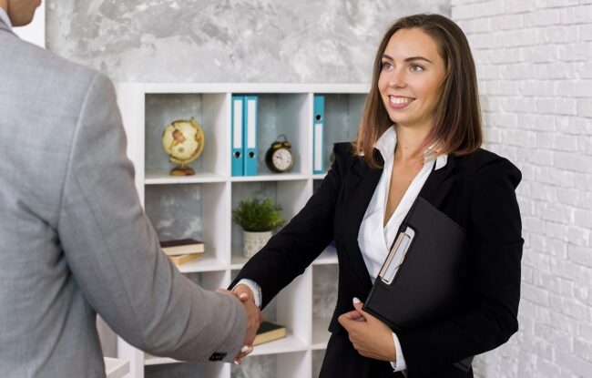 handshake6-fp Man and woman in business attire shaking hands.