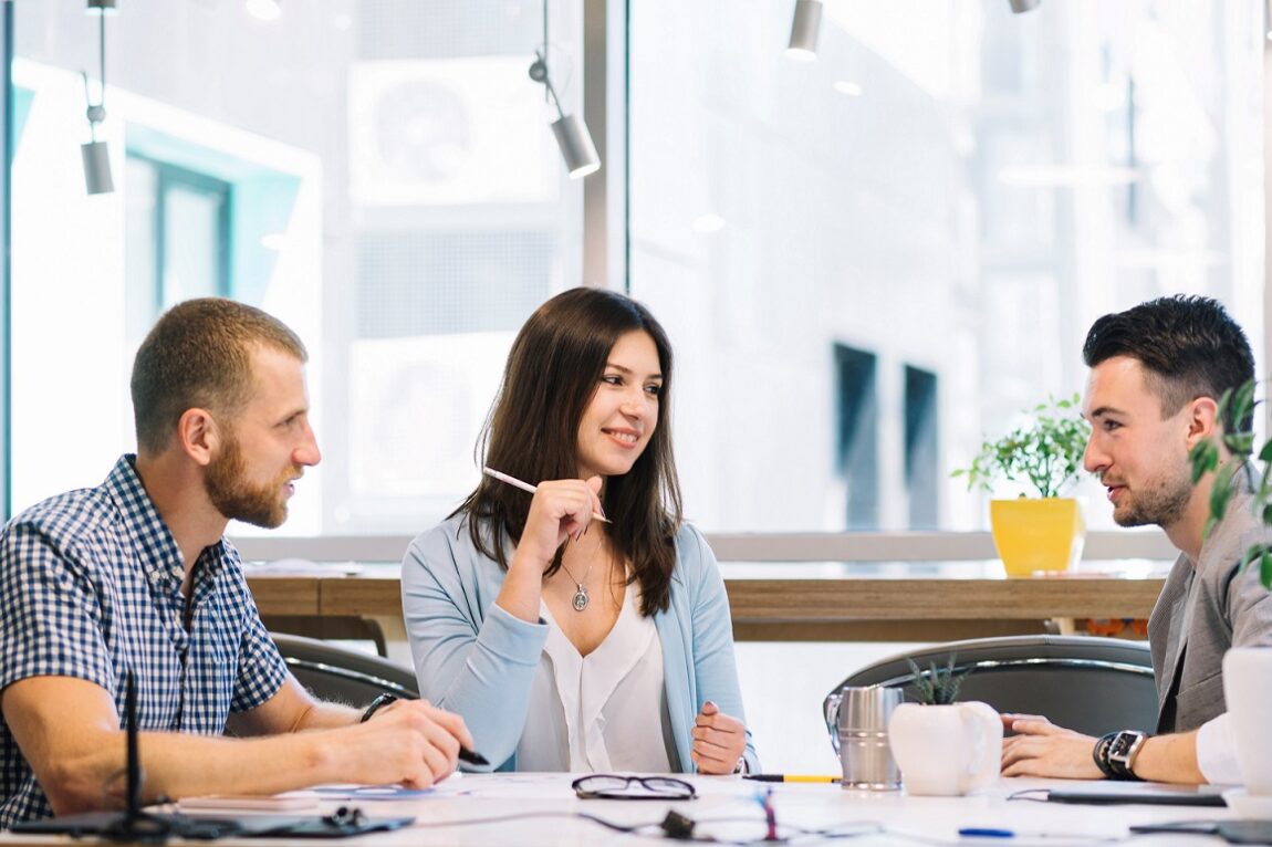 Two men and a woman having a conversation in office setting illustrate blog "What Are Soft Skills? "