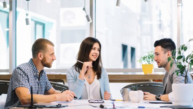 softskills-FP Two men and a woman having a conversation in office setting illustrate blog "What Are Soft Skills? "