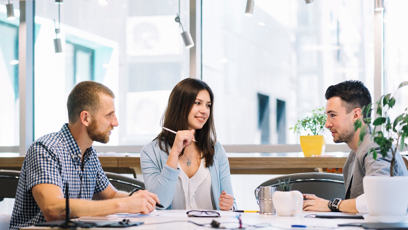 softskills-FP Two men and a woman having a conversation in office setting illustrate blog "What Are Soft Skills? "