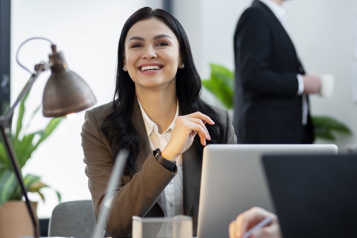 Smiling woman in business attire illustrates blog "Project Management Basics for Business Owners"